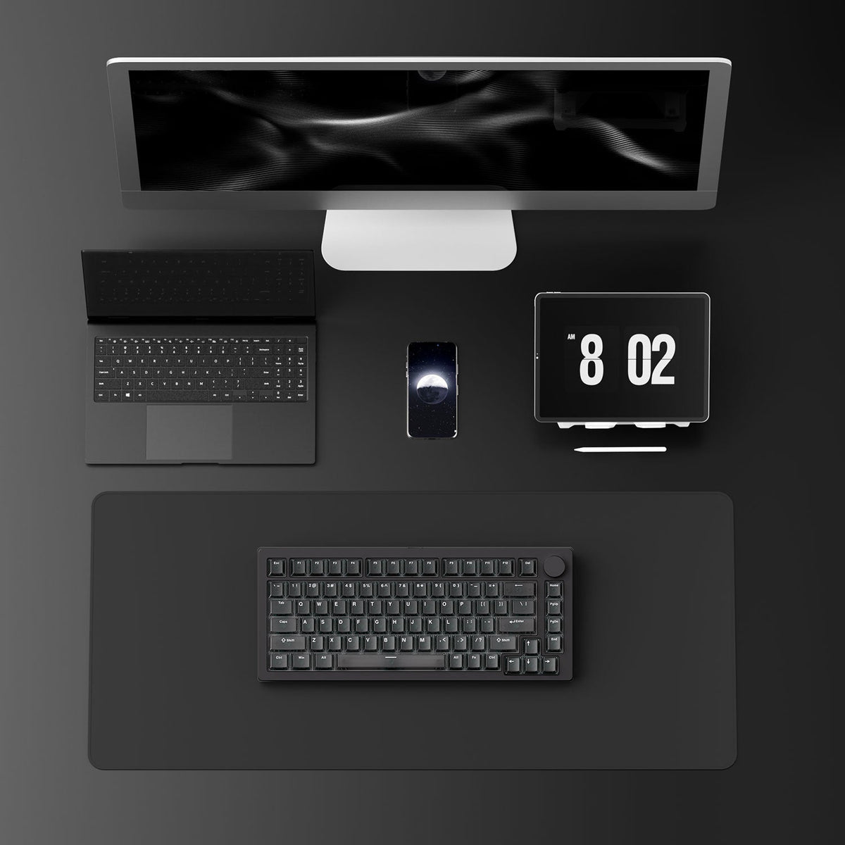 Modern office desk setup with computer monitor, MonsGeek M1 V5 HE Magnetic Keyboard, mouse, and digital clock on a dark surface.
